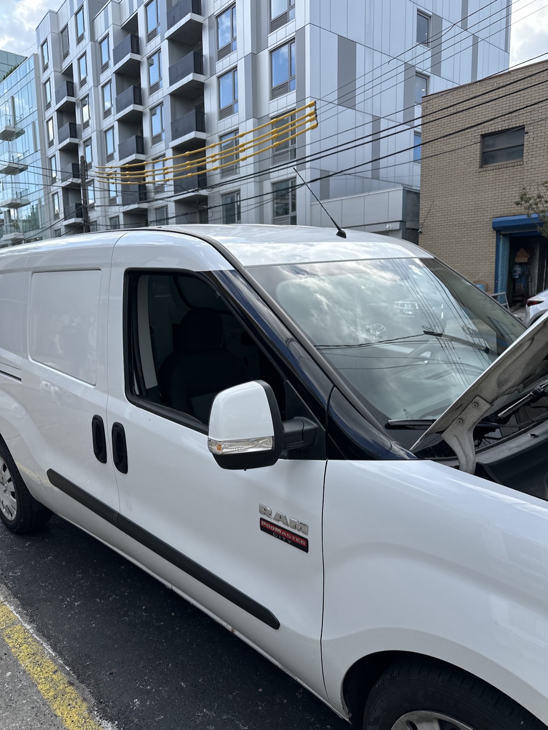 A Ram ProMaster City van with the hood open, in for service